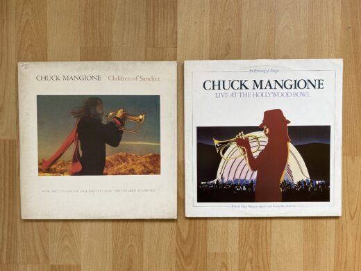 Zwei Vinyl-Schallplatten von Chuck Mangione – Children of Sanchez (Soundtrack, 1978) und An Evening of Magic: Live at the Hollywood Bowl (Live-Doppelalbum, 1979) – liegen nebeneinander.